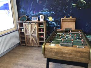 a room with a foosball table in front of a wall at Hotel de la Forêt in Saint-Hilaire-de-Riez