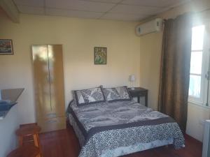 um quarto com uma cama e uma janela em Departamento en Luis Guillon em Luis Guillón