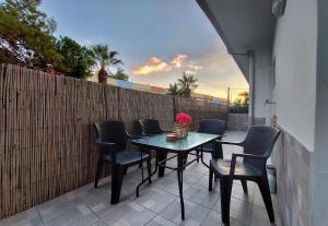 a patio with a table and chairs and a fence at Holiday House Heraklion in Heraklio
