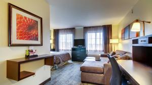 a hotel room with a bed and a couch at Staybridge Suites Madison - East, an IHG Hotel in Madison