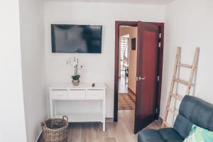 a living room with a couch and a tv on a wall at TIKI street side Studio with shared water front terrace at Grand Case in Grand Case