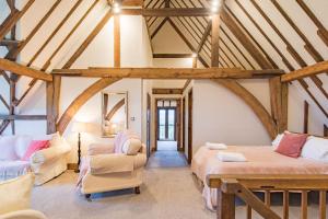 a attic room with two beds and a chair at The Canterbury Barn by Bloom Stays in Canterbury