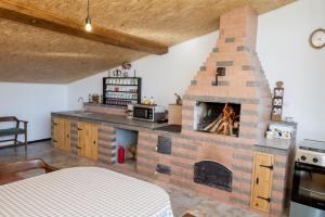 eine Küche mit einem gemauerten Kamin in einem Zimmer in der Unterkunft Open View Place The A Frame in Scăricica
