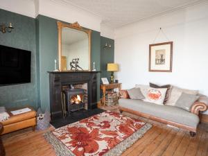 een woonkamer met een open haard, een bank en een spiegel bij Glasfryn in Cemaes Bay