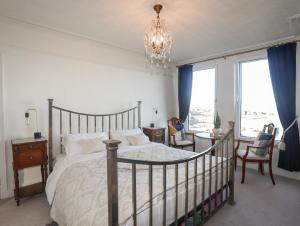 een slaapkamer met een bed en een kroonluchter bij Glasfryn in Cemaes Bay