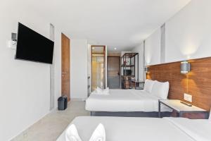 um quarto de hotel com duas camas e uma televisão em Morelos By HomiRent em Querétaro