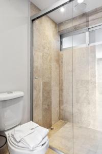 a bathroom with a toilet and a glass shower at Morelos By HomiRent in Querétaro