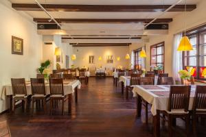 a restaurant with tables and chairs in a room at Hotel Beskid in Milówka