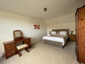 een slaapkamer met 2 bedden, een spiegel en een dressoir bij Roslin in Portinscale