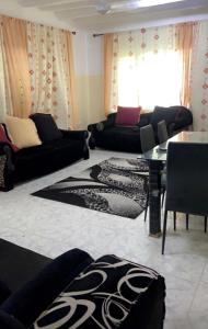 a living room with black couches and a table at Malindi luxury apartment. in Malindi