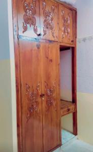 una puerta de madera en una habitación con un estante en Malindi luxury apartment., en Malindi