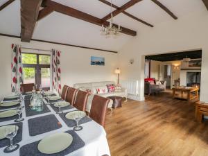 a dining room with a table and a living room at Meadowfields in Kidderminster