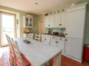 a kitchen with a wooden table and chairs in a room at Bourblach in Mallaig