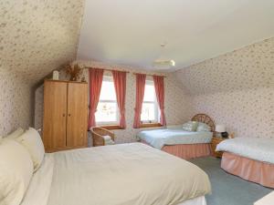 a bedroom with two beds and two windows at Bourblach in Mallaig
