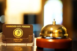 a hanover city pensionarmaarmaulator with a bell on a table at Hannover-City-Pension in Hannover