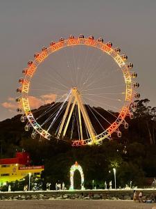 une grande roue ferris dans un parc la nuit dans l'établissement APARTAMENTO COM VISTA PARA O MAR NA Av ATLANTICA EM BALNEARIO CAMBORIU, à Balneário Camboriú