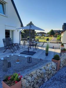 un patio con mesa y sombrilla en Ferienhaus Färber, en Lahr