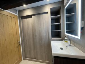 a bathroom with a sink and a wooden door at Cragside Cottage in Troutbeck +7 photos