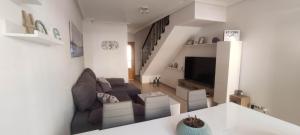 Una sala de estar con un sofá y un televisor. en Villa Terreros, en San Juan de los Terreros