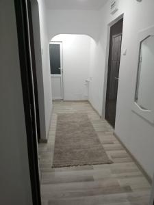 un pasillo con una puerta y una alfombra en el suelo en Criss Apartament, en Suceava