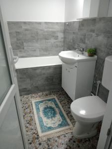 a bathroom with a toilet and a tub and a sink at Criss Apartament in Suceava