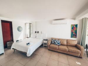 ein Schlafzimmer mit einem Bett und einer Couch in der Unterkunft GRAND VIEW Luxury water front studio at Grand Case in Grand Case