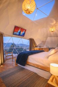 a bedroom with a bed and a tv in a tent at Domo Pajcha, Samaipata Glamping in Samaipata +36 photos