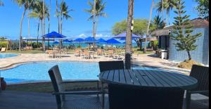 a patio with a table and chairs next to a pool at Baía Branca Beach Resort in Tamandaré