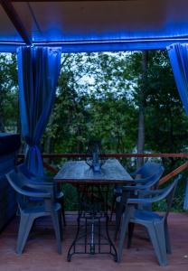 - une table et des chaises sur une terrasse couverte avec des lumières bleues dans l'établissement Ośrodek Dąbrówka, à Suwałki