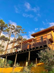 a house with a wooden deck on a building at Casa Latitude 22 Casais e Famílias com vista exclusiva in São Bento do Sapucaí