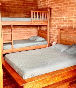 two bunk beds in a room with a brick wall at Casa Latitude 22 Casais e Famílias com vista exclusiva in São Bento do Sapucaí +48 photos