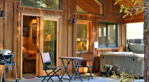 un porche de una casa con sillas y mesa en Chewuch Inn & Cabins, en Winthrop