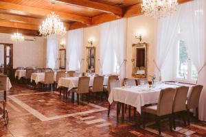 a conference room with tables and chairs and chandeliers at Hotel Zamek Chałupki in Ruderswald
