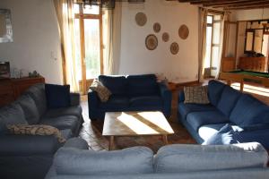 - un salon avec des canapés bleus et une table dans l'établissement Le Grand Launay, à Pacé