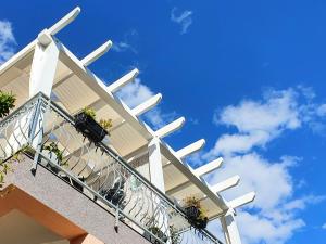 a balcony of a building with potted plants on it at Apartmani Villa Lilliana in Tribunj