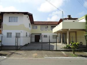 una casa blanca con una valla delante en Casa Balneário Camboriú, en Balneário Camboriú