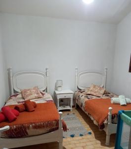 Duas camas num quarto com paredes brancas em Lombas Studio em Porto Santo