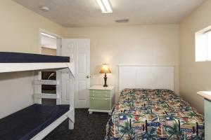 1 dormitorio con 1 cama y 1 litera con escalera en Cottages Christian Retreat, en Panama City Beach