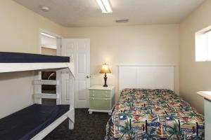 a bedroom with a bed and a bunk bed with a ladder at Cottages Christian Retreat in Panama City Beach +75 photos