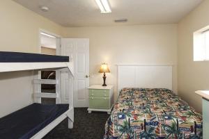 a bedroom with a bed and a bunk bed with a ladder at Cottages Christian Retreat in Panama City Beach
