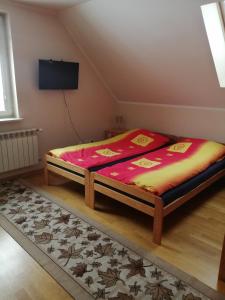 een bed zittend in een kamer met een avertisementatronatronstrategiestrationstrationstrationstrationstrationstrationstrationstrationstrationstration bij Agroturystyka Sajkiewicz in Suchowola