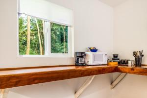 a kitchen counter with a microwave and a window at Puni Mauka B 31 plus day rental in Pahoa