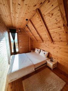 1 dormitorio en una cabaña de madera con 1 cama en CASA MIA, en Kupres
