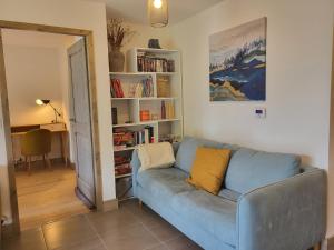 a blue couch in a living room with a book shelf at Le Criou - 3 bedroom apartment 5 minutes walk to the village centre in Samoëns