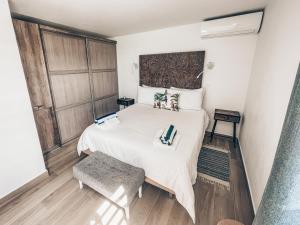 1 dormitorio con 1 cama blanca grande y suelo de madera en PARADISE VIEW 1 bed-room water front studio at Grand Case, en Grand Case