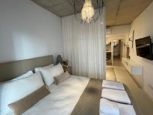 1 dormitorio con 1 cama blanca grande con lámpara de araña en Lovely studio in Alto Palermo area 4 pax en Buenos Aires