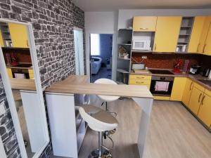 a kitchen with yellow cabinets and a brick wall at Altes Gut Berka in Sondershausen