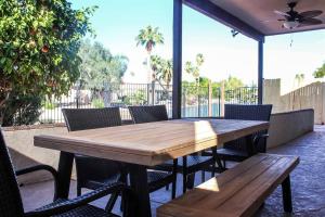 a wooden table and chairs on a patio at Lakefront Hacienda w/ Paddle Boat, Pool, Hot-tub, Tennis in Chandler