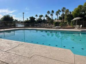 een groot zwembad met blauw water in een resort bij Lakefront Hacienda w/ Paddle Boat, Pool, Hot-tub, Tennis in Chandler