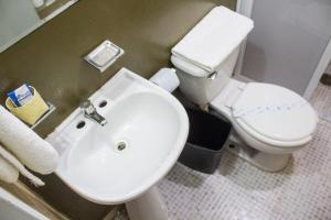 een badkamer met een witte wastafel en een toilet bij Casa Gubidxa in Oaxaca City